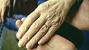 Carer and pensioner holding hands