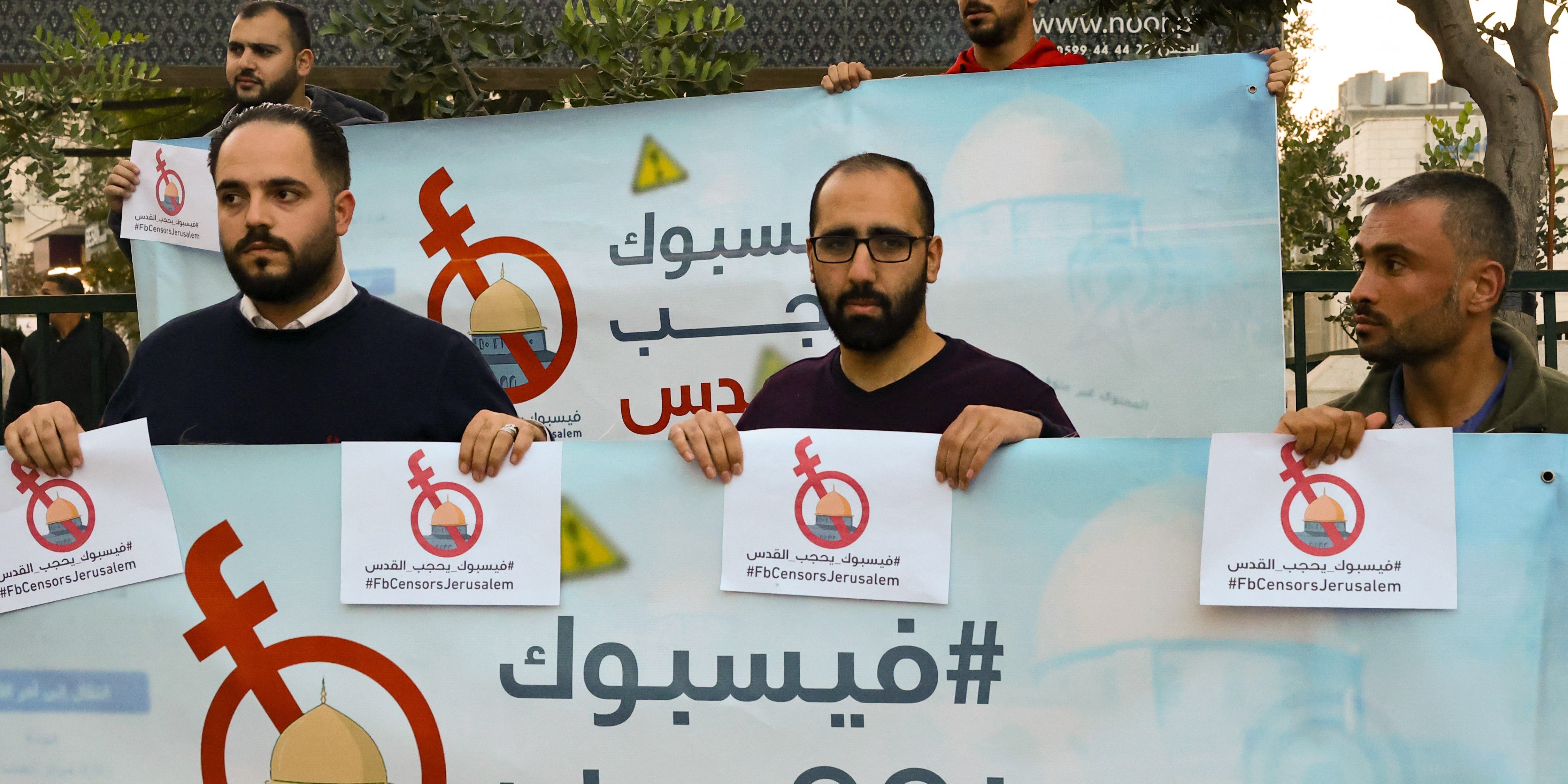 Palestinian activists and journalists hold banners with their campaign hashtag  '#FBCensorsJerusalem' as they protest against what they consider censorship by the social media outlet Facebook of Palestinian content, in the occupied-West Bank city of Hebron, on November 24, 2021. - Palestinian journalists have raised the alarm over what they describe as unjust suppression of their content on Facebook, a claim backed by rights groups but rejected by the social media giant. (Photo by HAZEM BADER / AFP) (Photo by HAZEM BADER/AFP via Getty Images)