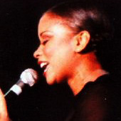 close-up profile of Niki Haris singing into a microphone