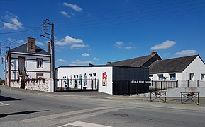 Photographie en couleurs d'un ensemble de bâtiments avec une cour close d'une grille portant la mention « ECOLE RENE CASSIN ».