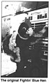 Blue Hen mascot standing in front of a fire truck.