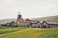 A collection of brick-and-mortar structures on a grassy hillside