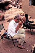 ASC Leiden - W.E.A. van Beek Collection - Dogon tourism 08 - Filmer Nigel Evans enjoys a beer, Tireli, Mali 1990.jpg