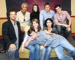 Firefly Flanvention, décembre 2005. Allongé au premier plan : Nathan Fillion ; assise à gauche, Jewel Staite, et à droite, Morena Baccarin ; autour d'eux, de gauche à droite : Adam Baldwin, Ron Glass, Summer Glau, Alan Tudyk, Sean Maher.