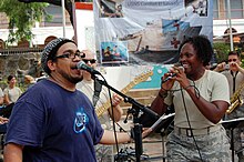 US Navy 090628-N-5234F-042 Tech Sgt. Keisha Gwin-Goodwin, a member of the U.S. Air Forces Southern Band, sings with a member of the local band.jpg