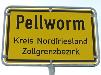 Einziges Ortsschild auf Pellworm an der Straße vom Fähranleger: Bedeutet auch, überall auf Pellworm ist max. 50 km/h angesagt. Nur echt, wenn der i-Punkt von „Zollgrenzbezirk“ fehlt!