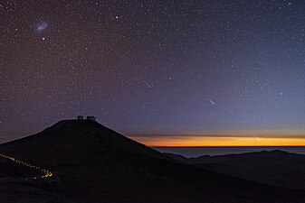 Paranal rasadxonasidan janubiy osmon boʻylab harakatlanayotgan ikkita kometa bilan quyosh botishi koʻrinishi