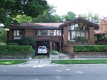 One story house with gabled roofs, wide overhangs, and leaded glass windows.