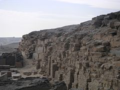 Ruined wall of bricks and a few stones in the desert.