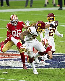 A man running with a football in the process of returning it for a touchdown.