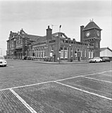 Voor- en zijgevel van het Station Zandvoort aan Zee, met de watertoren, gezien vanaf de Statonsstraat; februari 1974.