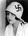 Den amerikanske filmstjerna Clara Bow med hakekors på klokkehatt og jakkeslag «som beskyttelse mot uhell på fredag den trettende» våren 1928 Foto: Los Angeles Times