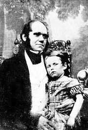 Darwin in his thirties, with his son dressed in a frock sitting on his knee.