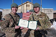 U.S. Army Cpl. Joshua Power, right, assigned to Bravo Troop, 3rd Squadron, 71st Cavalry Regiment, 10th Mountain Division, holds an honorable discharge certificate during a re-enlistment ceremony at Forward 140102-A-RU942-057.jpg