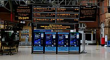 Deserted train station with "stay at home, protect the NHS, save lives" sign displayed.