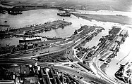 Luchtfoto van het Oostelijk Havengebied, gezien naar het noordoosten, in het midden het Rangeerterrein De Rietlanden; omstreeks 1930.