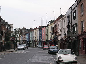 A road with some cars parked on it next to a line of houses