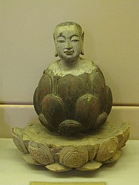 Bocah Buddha bangkit dari teratai. Kayu merah tua dan berlapis emas, Dinasti Trần-Hồ, abad ke-14-15. Patung untuk beribadah. Museum Nasional Sejarah Vietnam, Hanoi.