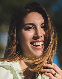 A woman with light brown hair smiling into the camera.