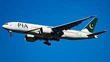 Aircraft landing approach. Side view of twin-engine jet in flight with flaps and landing gear extended.