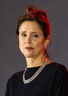 Headshot of Caucasian woman with brown hair wearing black with silver necklace