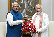 Governor of Jharkhand and Telangana, and Lieutenant Governor of Puducherry CP Radhakrishnan holding a bouquet of flowers with Prime Minister of India Narendra Modi