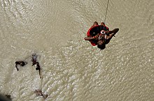 A flood victim being rescued by Indian Air Force helicopter in al view of the flood affected villages where the relief material being dropped by the IAF helicopter in Bihar