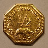 Eine achteckige Goldmünze, unter der Zahl 1/2 ist ein Bär abgebildet, darüber steht CALIFORNIA GOLD