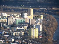 Vue aérienne du quartier olympique et de ses tours. À droite et au fond, on voit la rivière.