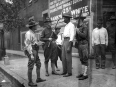 Armed soldiers questioning a black resident in Washington D.C. in 1919.