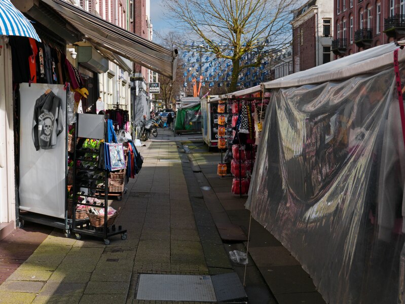 File:2023 Amsterdam - a view behind the market stalls at the street Albert Cuypstraat, in the sunlight of March - free download photo in Dutch street photography by Fons Heijnsbroek, Netherlands.tif