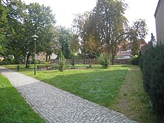 Fußweg auf dem Kirchplatz der Nikolaikirche Lauchhammer-Mitte Südwestansicht und Spruchpfad Westansicht.jpg