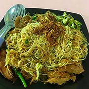 Fried onions garnishing a plate of chicken noodles