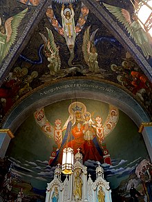 A beautifully painted depiction of the Madonna & Child among the clouds. On the higher ceiling is a depiction of Jesus flanked by angels and saints.