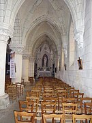 Photographie en couleurs de l'intérieur du bas-côté d'une église.