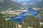 An aerial view of a large river flowing through forested hills