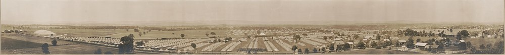 Many rows of white tents, seen from a distance