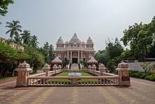 A picture of the temple (The Universal Temple at Sri Ramakrishna Math, Chennai). Picture taken on 10/27/2024 by Sundar Karthikeyan. Shows the front facade with the leading steps and the small enclave with a description of the mission.