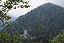 Photograph of stone fortress in wooded mountains.