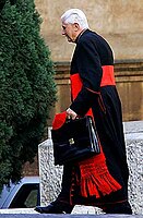 Toenmalige kardinaal Ratzinger in de dagelijkse kledij: zwarte soutane met rode knopen en rode zoom, rode sjerp en rode solideo.