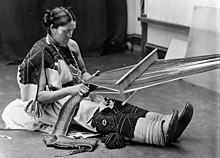 We'wha, in traditional dress and jewelry, working at a backstrap loom.