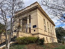 An oblique view of a large salmon colored two-story stone building, of some prominence