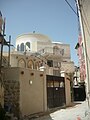 Photographie d'un bâtiment blanc de plan circulaire situé dans une ville du Moyen-Orient.