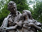 Bronze statue of a seated man with a young girl beside him