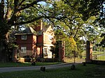 Lodge, among trees, at the entrance to a country house