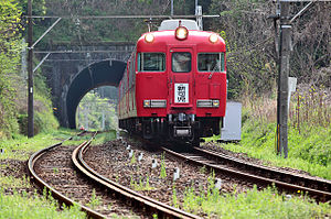 An image of a Meitetsu 7700 series electric multiple unit on the Hiromi Line between Zenjino and Nishi Kani stations, near Aigi tunnel, in April 2009.