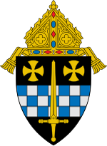 An image of a coat of arms: a golden sword laid over a fess chequy blue and silver and two gold rounded crosses pattée in chief, with a bishop's mitre surmounting the shield.