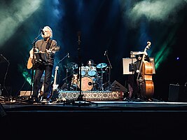 Wolf Bros performing on stage – Bob Weir (guitar, vocals), Jay Lane (drum set), Don Was (upright bass)