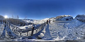 Photographie 360° du point d'observation du Tchike-Taman, en hiver, avec un enneigement important dans le paysage. Le point donne sur une vallée enneigée, et un parking se trouve sur le côté de l'image.