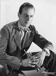 Sur cette photo en noir et blanc, Boris Vian est assis, tourné vers la droite de l'image, le regard dans le vide. Il porte un costume et un nœud papillon, et tient dans ses mains une petite trompette, qu'il appelait « trompinette ».